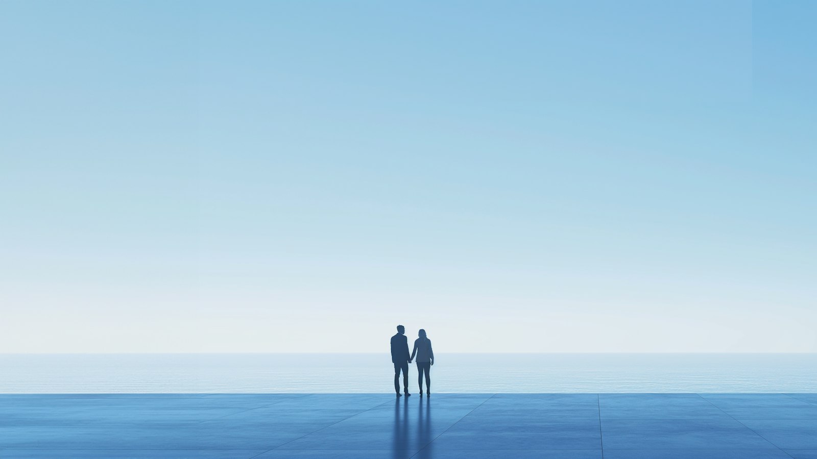 A couple holding hands on a terrace overlooking the ocean