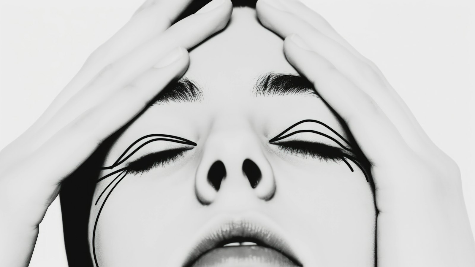 A black and white portrait of a person with hands on their forehead