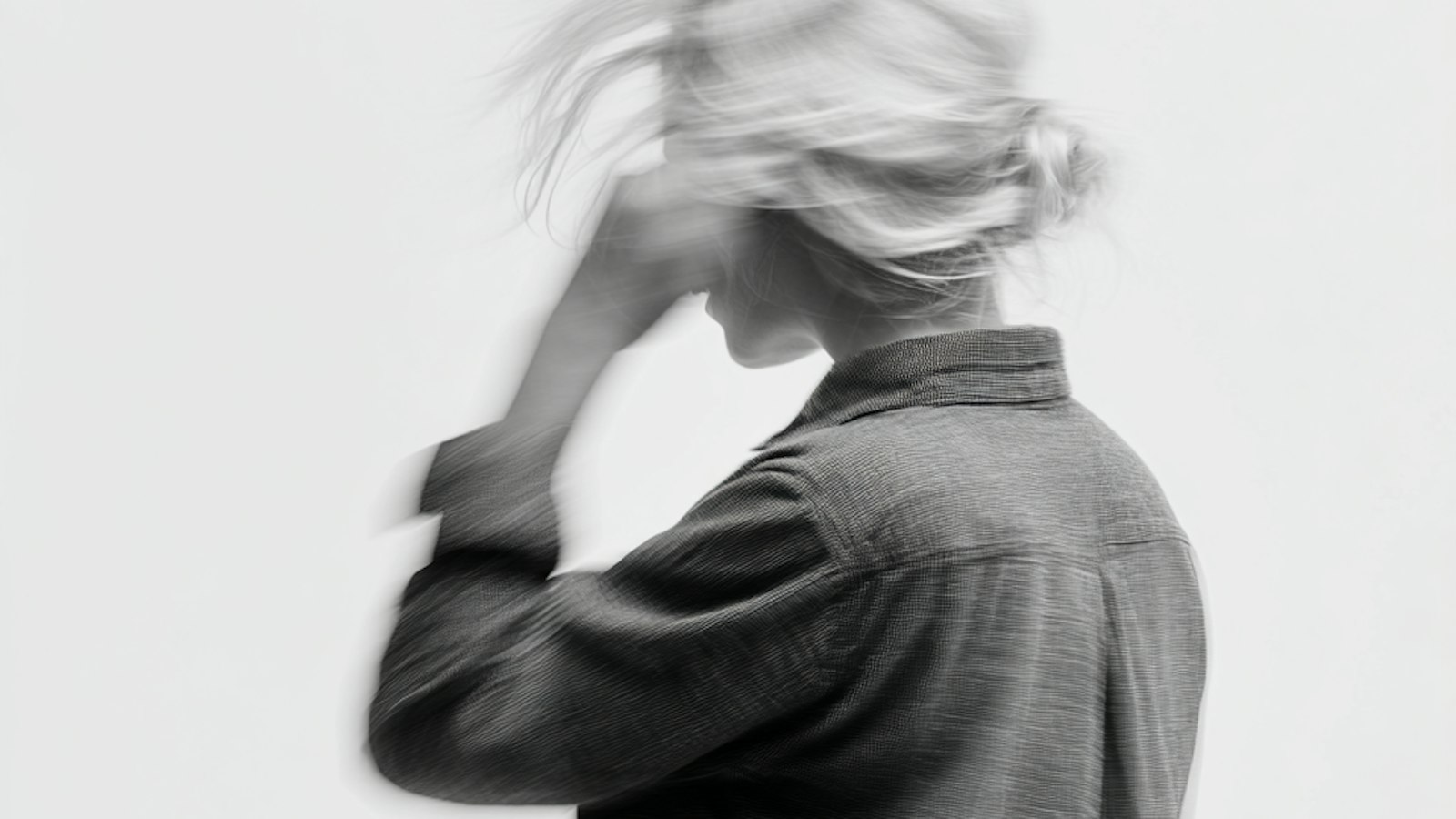 A blurred black and white side profile of a person